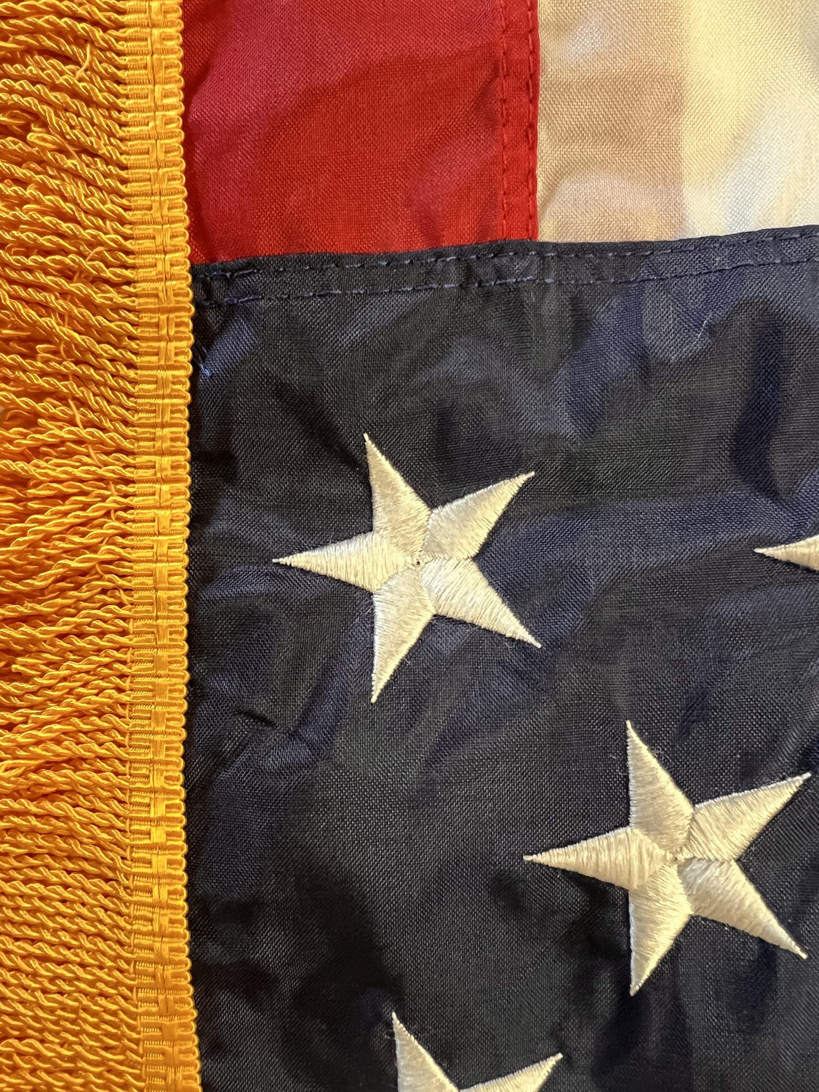 Gold fringe and embroidered stars on a ceremonial U.S. flag