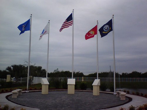 Five flagpoles at a memorial plaza