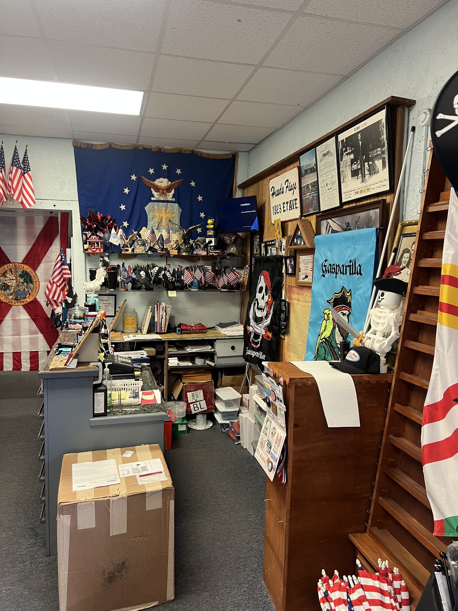 Racks of flags and a Head's Flags sign inside the shop